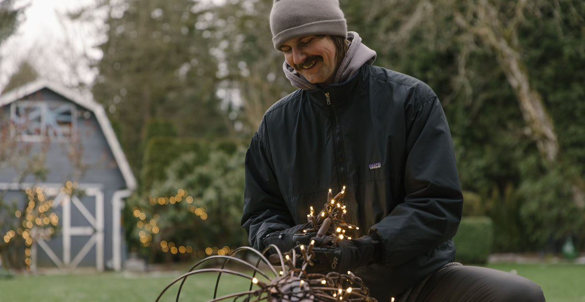 Smiling Christmas light installer holding lights wearing gloves