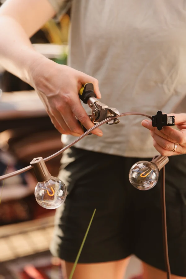 Hands assembling a string of globe lights